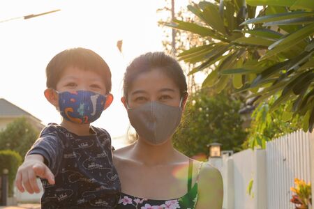 asian cute boy and woman mother wearing fabric mask in outdoor morning day protect your self from air pollution and disease epidemicの写真素材