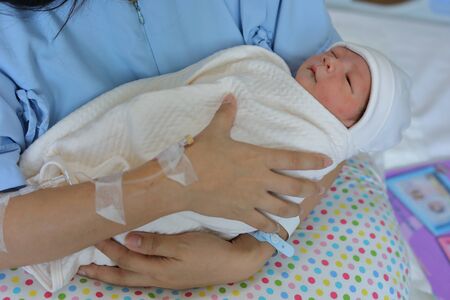 woman mother holding a baby with feeling love after childbirth newborn in hospital