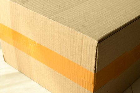 brown carton paper box package with packing tape stick
