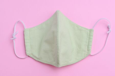 design of green face mask handmade sewing from fashion fabric cotton cloth on pink background