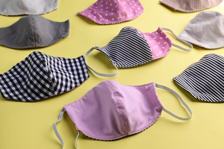 flat lay design of colorful fashion face mask handmade from fabric cloth on yellow backgroundの写真素材