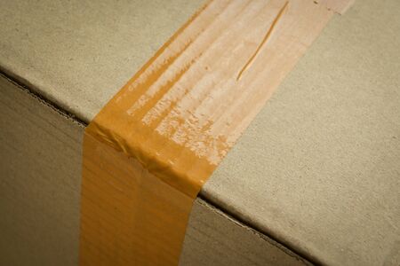 brown carton paper box package with packing scotch tape stick