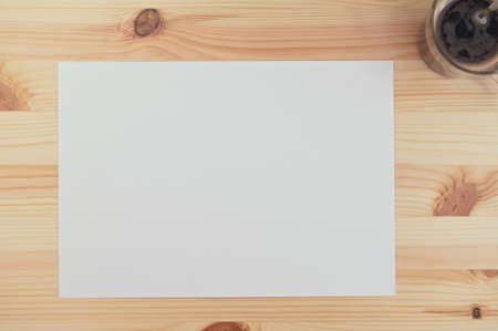 white paper on wood table with coffee