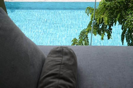 gray pillow put on bed, pool viewの写真素材