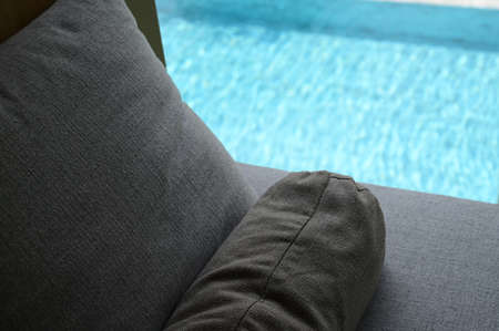 gray pillow put on bed, pool viewの写真素材
