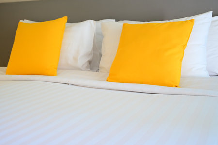 yellow pillow on white bed, interior designの写真素材