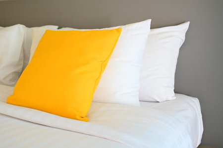 yellow pillow on white bed, interior designの写真素材