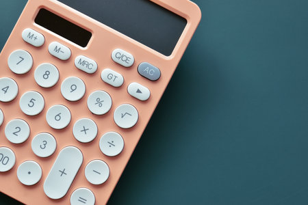 close up modern peach colour pastel calculator and white button on blue background, business and finance accounting conceptの写真素材