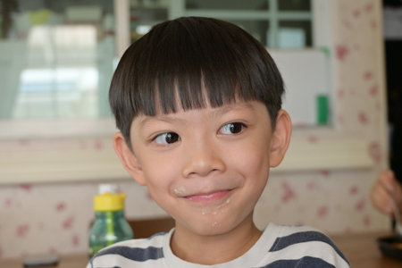 little messy boy with dirty mouth, funny happy kid portrait, tasty foodの写真素材