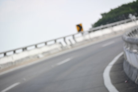 highway curve with safety barrier on road asphalt, blurred imageの写真素材
