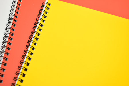 yellow and orange notebook on white backgroundの写真素材