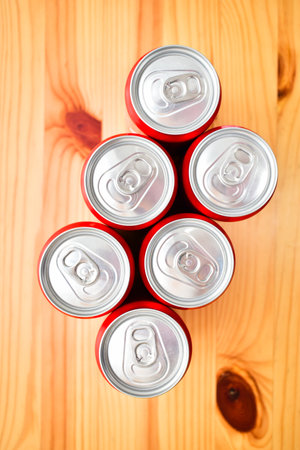 group of aluminium red cans soft drink put on brown wooden tableの写真素材