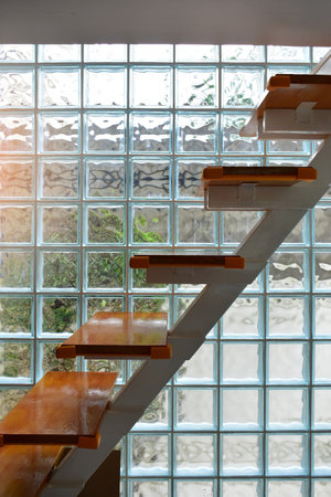 close up glass block wall and wooden staircase with golden natural light background, interior designの写真素材