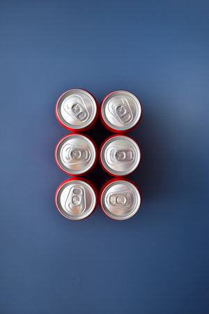 close up top of aluminium red cans soft drink put on blue texture background