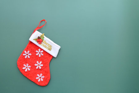 red wool winter sock on green background, christmas decorationの写真素材
