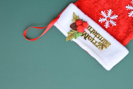 red wool winter sock on green background, christmas decorationの写真素材