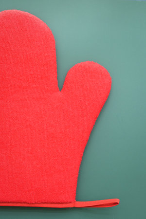 red wool winter glove on green background, christmas decorationの写真素材