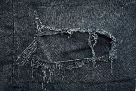 torn black danim texture background, textile of jeans fashion for clothing designの写真素材