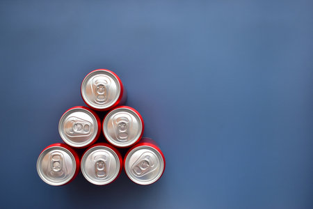 close up group of aluminium red cans soft drink put on blue texture backgroundの写真素材