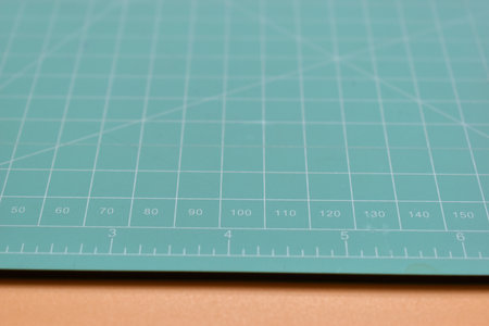 green cutting mat on orange background, object tool for designの写真素材