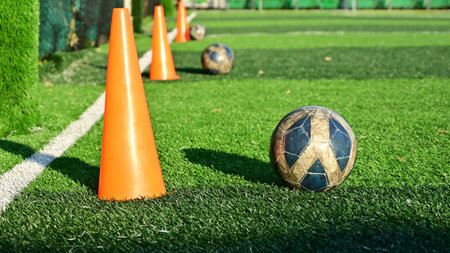 artificial green grass soccer field with training cone and ball