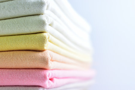 stack of colourful cotton clothes, pile of clothing on white backgroundの写真素材