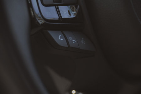 interior view of car with black leather, close up steering wheel with button