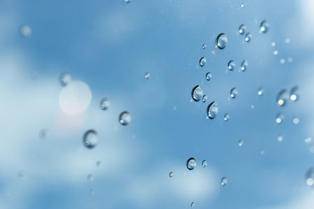 water drop on mirror with blue sky and white cloud background