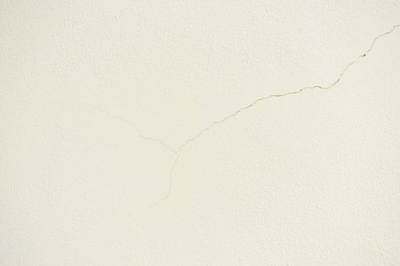crack on white wall from earthquake, construction industry