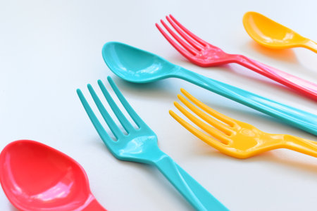 colorful spoon and fork isolated on white background, plastic cutlery for picnicの写真素材