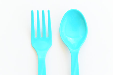 blue spoon and fork isolated on white background, plastic cutlery for picnicの写真素材