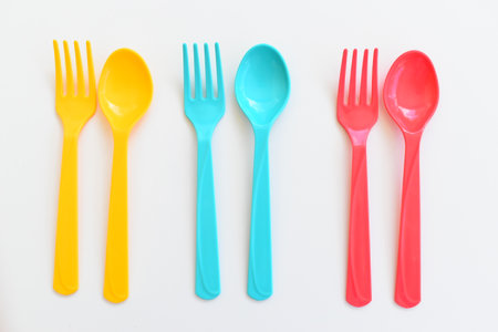 colorful spoon and fork isolated on white background, plastic cutlery for picnic
