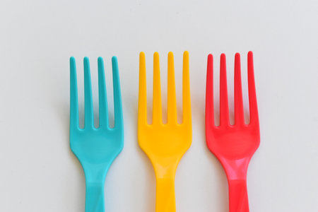 colorful fork isolated on white background, plastic cutlery for picnicの写真素材