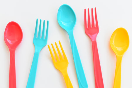 colorful spoon and fork isolated on white background, plastic cutlery for picnicの写真素材