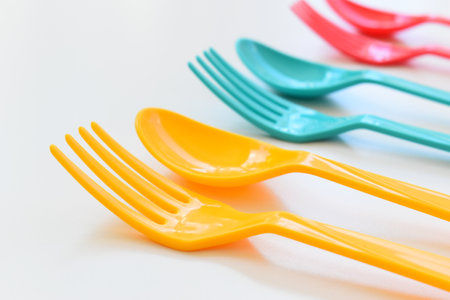 colorful spoon and fork isolated on white background, plastic cutlery for picnicの写真素材