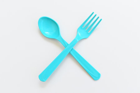 blue spoon and fork isolated on white background, plastic cutlery for picnicの写真素材