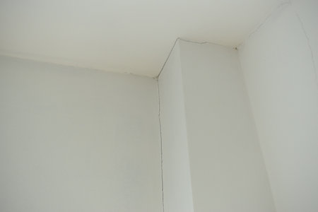 crack of pole on white wall from earthquake, construction industryの写真素材