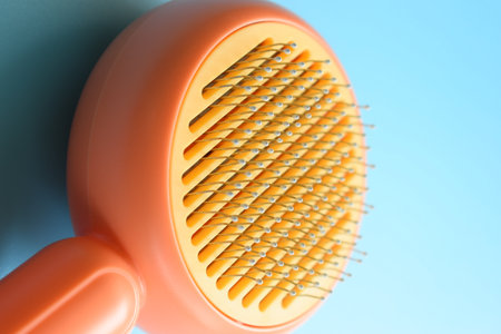 pastel orange comb on blue background, hair brush for petの写真素材