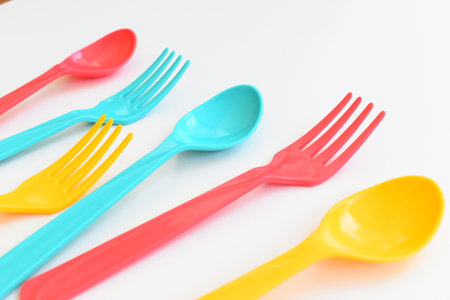 colorful spoon and fork isolated on white background, plastic cutlery for picnicの写真素材
