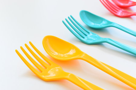 colorful spoon and fork isolated on white background, plastic cutlery for picnicの写真素材