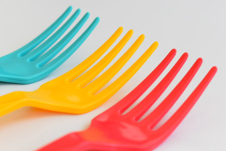 colorful fork isolated on white background, plastic cutlery for picnicの写真素材