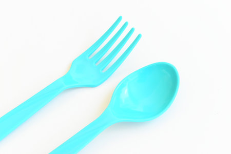 blue spoon and fork isolated on white background, plastic cutlery for picnicの写真素材