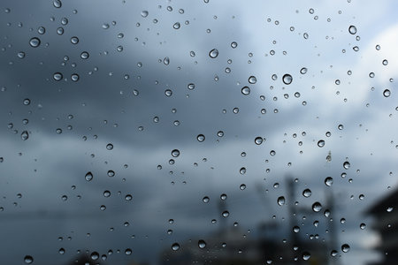 water drop on window with dark cloudy sky backgroundの写真素材