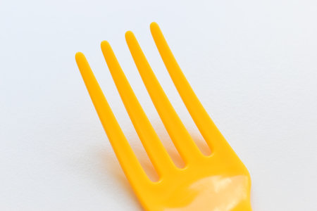yellow fork isolated on white background, plastic cutlery for picnic
