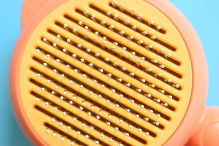pastel orange comb on blue background, hair brush for petの写真素材