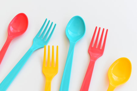 colorful spoon and fork isolated on white background, plastic cutlery for picnicの写真素材