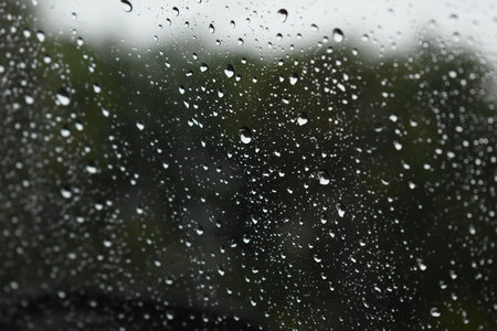 water drop on mirror in rainy day, blur natural backgroundの写真素材