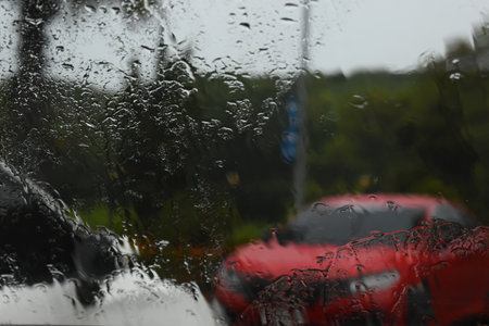 red car on parking in raining day, abstract blur backgroundの写真素材