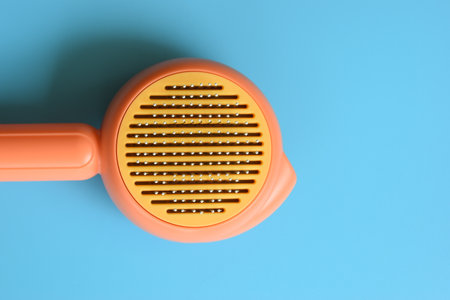 pastel orange comb on blue background, hair brush for petの写真素材