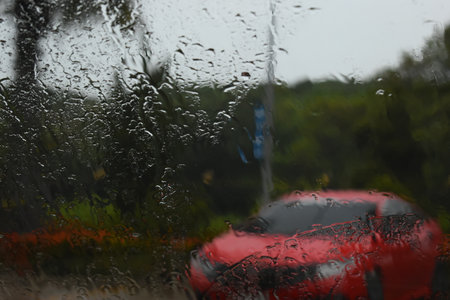 red car on parking in raining day, abstract blur backgroundの写真素材